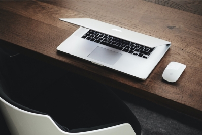 Atmospheric picture of a half-open laptop on a wooden desk